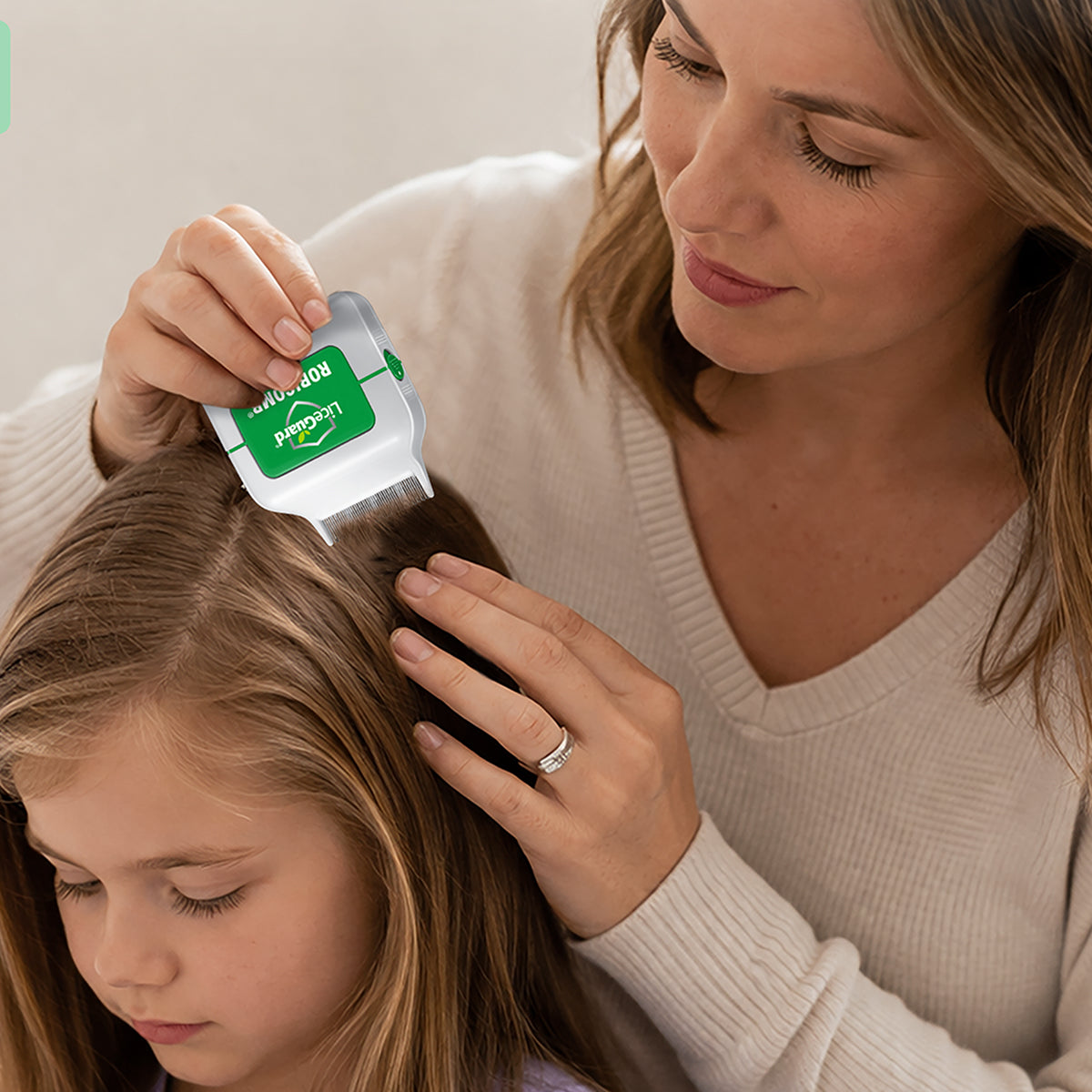 Woman using Robicomb on a child's hair to check for lice
